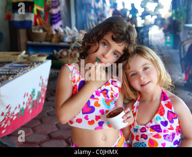 Belles sœurs petites filles de manger du chocolat crème glacée au marché mexicain Banque D'Images