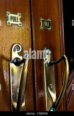 Poignées de porte en laiton massif montés sur les portes en chêne foncé à l'entrée de opéra de Buxton à Buxton, Derbyshire, Angleterre Banque D'Images