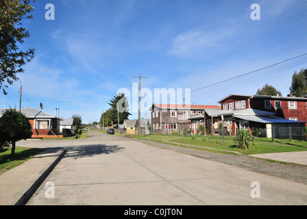 Street view Village de maisons en bois brun sur une route calme autour de la Plaza Martin Ruiz, Chacao, Ile de Chiloé, Chili Banque D'Images