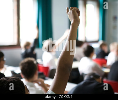 Les élèves mettent leurs mains pour répondre à une des questions à Maidstone Grammar school à Maidstone, Kent, Royaume-Uni Banque D'Images