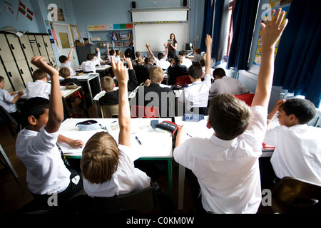 Les élèves mettent leurs mains pour répondre à une des questions à Maidstone Grammar school à Maidstone, Kent, Royaume-Uni Banque D'Images