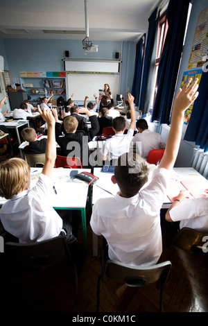 Les élèves mettent leurs mains pour répondre à une des questions à Maidstone Grammar school à Maidstone, Kent, Royaume-Uni Banque D'Images