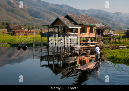 L'aviron à l'homme ethnie Intha sa maison sur pilotis sur le lac Inle au Myanmar Banque D'Images