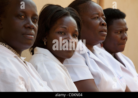 Un groupe d'infirmières et d'asseoir à l'extérieur une clinique de Kampala, Ouganda, Afrique de l'Est. Banque D'Images