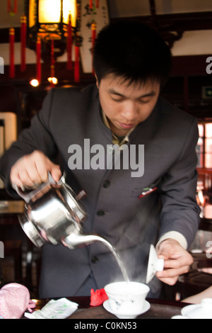 Chinese man pouring tea thé en chambre Yu Yuan Shangcheng, Yu Gardens Bazaar, Shanghai, Chine Banque D'Images