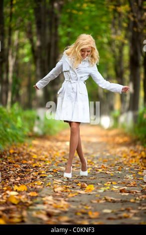 Young woman walking in autumn park. Banque D'Images