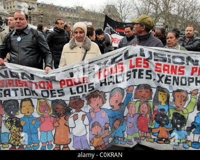 Paris, France, manifestation, Groupe d'immigrants sans documents, sans papiers, marche, tenue d'une bannière antiraciste, femme musulmane à la tête de l'écharpe, femme à hajib, protestataires droits humains multiraciaux Banque D'Images
