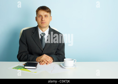 Business calme jeune homme est assis à un bureau dans le bureau Banque D'Images