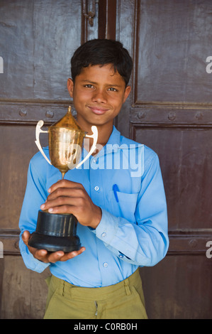 Portrait d'un écolier tient un trophée Banque D'Images