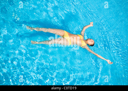 Jeune belle caucasian woman in bikini swimming in pool Banque D'Images