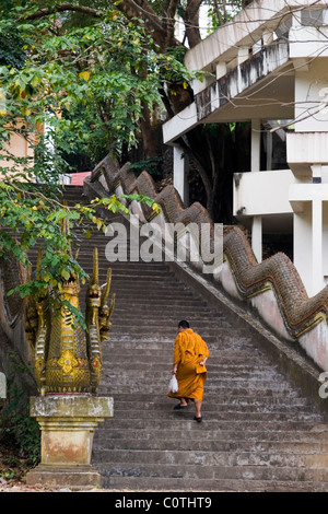 Un moine bouddhiste est l'ascension d'une longue et raide escalier de pierre menant à un magnifique temple bouddhiste à Mae Sai (SAE) de la Thaïlande. Banque D'Images