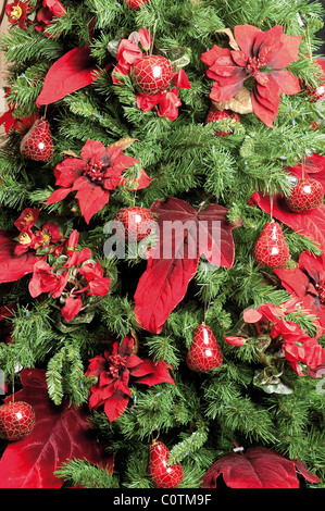 Arbre de Noël décoré de plantes poinsettia et babioles Banque D'Images