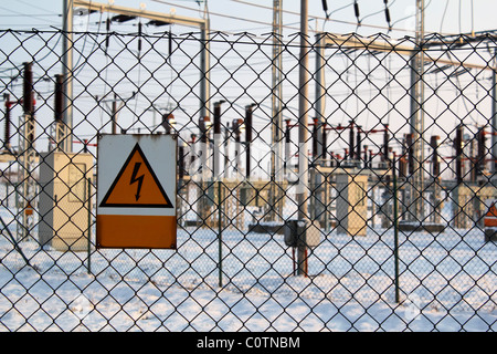 Scène d'hiver avec des panneaux d'avertissement sur les postes électriques haute tension Banque D'Images