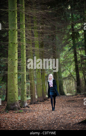 Jeune blonde modèle en minijupe et chemisier froissé de marcher seul dans les bois en automne Banque D'Images