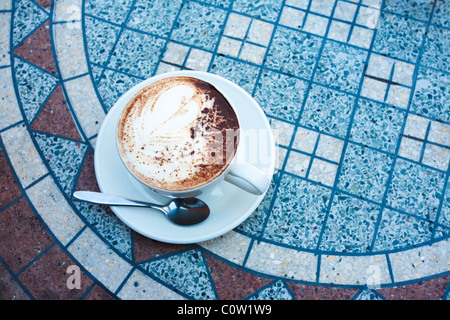 Tasse de cappuccino blanc sur table mosaïque dans street cafe Banque D'Images