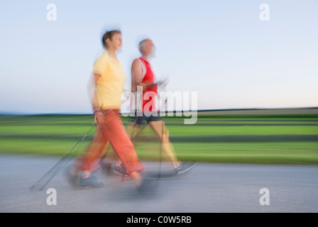 Senior woman and man walking, nordic walking, motion blur, région de Waldviertel, Basse Autriche, Autriche Banque D'Images