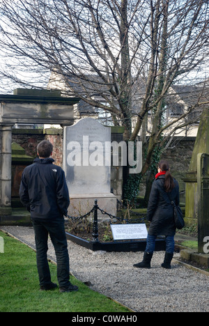Un couple visite la tombe de poète écossais Robert Fergusson dans Canongate Kirkyard, Édimbourg. Banque D'Images