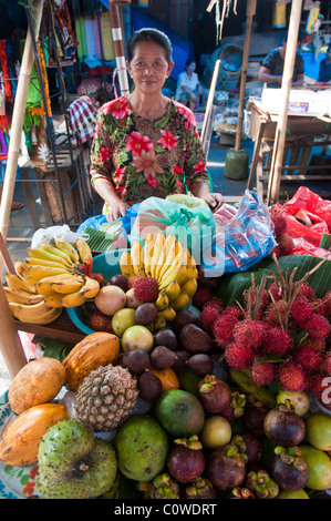 Femme vendant des fruits tropicaux dans le marché public à Ubud Bali Indonésie Banque D'Images