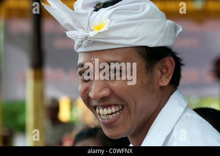 Souriant homme balinais portant la robe traditionnelle de tête udeng lors d'un festival de temple à Padang Bai dans l'est de Bali Indonésie Banque D'Images