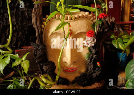 Image pierre bouddha décorées de fleurs , chinatown , Bangkok, Thaïlande Banque D'Images