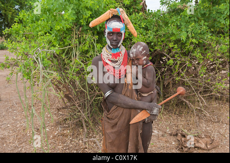 Jeune femme Karo avec colliers colorés tenant un bébé allaité, vallée de la rivière Omo, dans le sud de l'Éthiopie Banque D'Images