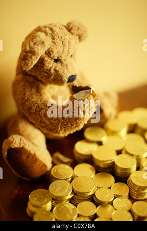 Ted tucks dans son chocolat pièce d'or de l'investissement. Banque D'Images