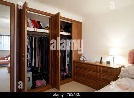 Une chambre avec meubles en chêne armoire avec portes ouvertes au Royaume-Uni. Banque D'Images