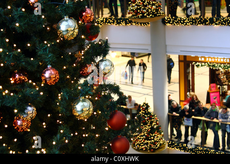 Centre commercial à plusieurs niveaux intérieurs décorés avec des arbres de Noël Banque D'Images