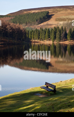 Coin banc en premier plan sur l'herbe à l'ombre avec vue sur la Vallée de Derwent reservoir avec reflets d'arbres et collines Banque D'Images