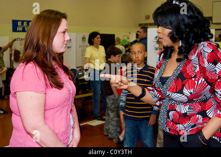Angry African American mother hurler sur Caucasian teacher en face de son fils Banque D'Images
