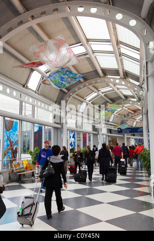 Les voyageurs aériens à pied à travers la borne airport corridor sur moyen de portes des aéroports, l'aéroport O'Hare, à Chicago, Illinois, États-Unis Banque D'Images