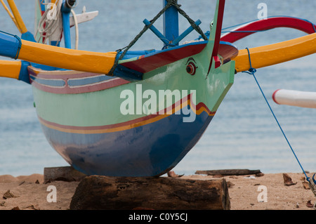 Bateau de pêche balinais appelé un jukung sur la plage de Sanur Bali Indonésie Banque D'Images