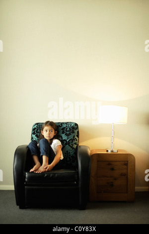 Fille est assise dans un fauteuil de style art déco avec des tiroirs et lampe Banque D'Images