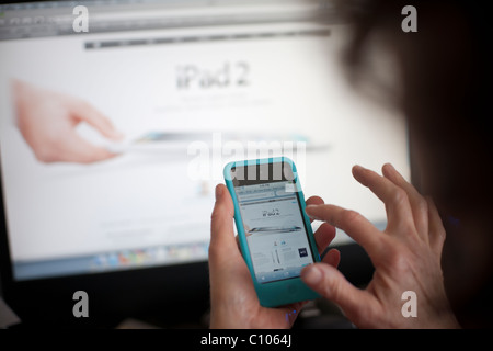 Un client qui navigue sur le site Internet Apple Store, avec le nouvel iPad 2, sur son iPod à New York Banque D'Images