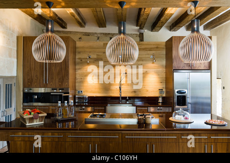 Les lampes secto en cuisine avec poutres au plafond et le plan de bouleau Asselin Banque D'Images