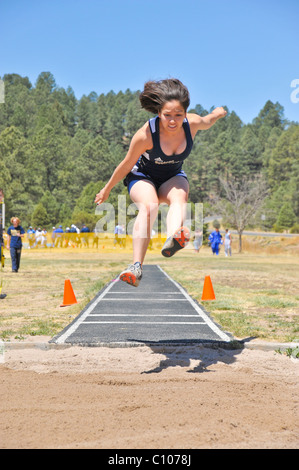 Fille de l'école des adolescentes dans le planeur de l'athlète la piste d'athlétisme saut en longueur et la concurrence sur le terrain, dans la région de Ruidoso, Nouveau Mexique. Banque D'Images