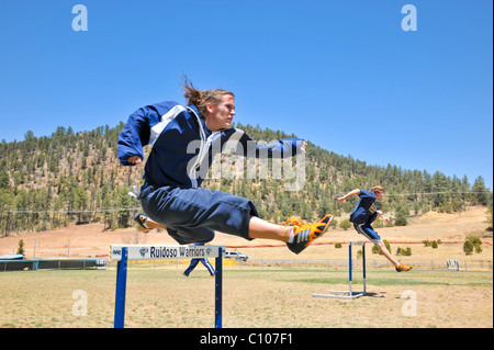 Les athlètes de l'école des adolescentes au chaud jusqu'à participer à la piste d'athlétisme et de la concurrence sur le terrain, à Albuquerque, Nouveau Mexique. Banque D'Images