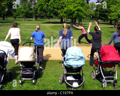 Les mères dans un parc qui participent à une classe de l'exercice en plein air Banque D'Images