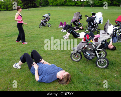 Les mères dans un parc qui participent à une classe de l'exercice en plein air Banque D'Images