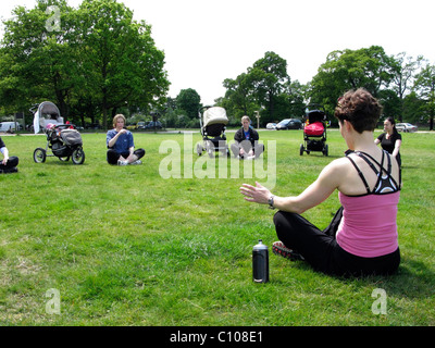 Les mères dans un parc qui participent à une classe de l'exercice en plein air Banque D'Images