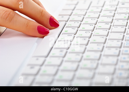 Mesdames les doigts sur un clavier d'ordinateur portable blanc Banque D'Images