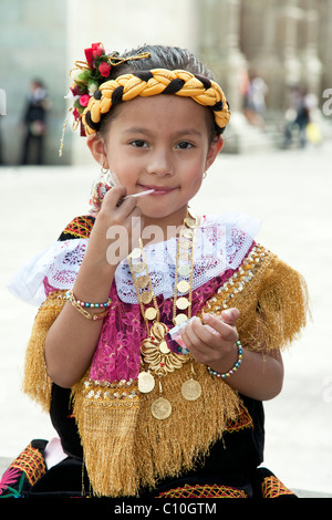 Petits Peuples mexican girl with lollipop en costume traditionnel sur la place devant la cathédrale principale de la ville d'Oaxaca au Mexique Banque D'Images