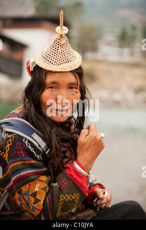 Laiya femme du Bhoutan de vendre ses marchandises à l'occasion d'un grand festival à Punakha, vêtu d'un chapeau de paille du Bhoutan et beau manteau tissé. Banque D'Images