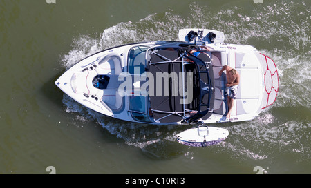 L'homme prenant un bain de soleil sur le pont d'un bateau sport, équipée de wakeboard, d'en haut Banque D'Images