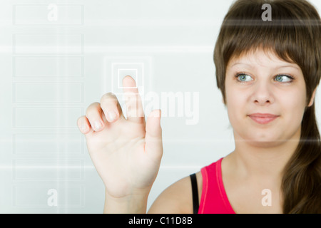 Fille appuie sur le bouton sur l'écran tactile aujourd'hui Banque D'Images