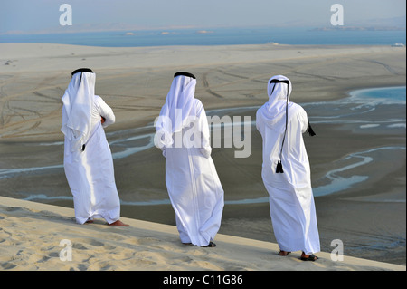 En costume traditionnel qatari avec gutra, en face de la plage de Khor Al Udeid, Khor El Deid, Mer Intérieure, desert miracle du Qatar Banque D'Images