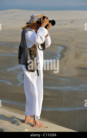 Photo photographe avec vest, arabes, en face de la plage de Khor Al Udeid, Khor El Deid, Mer Intérieure, desert miracle du Qatar Banque D'Images