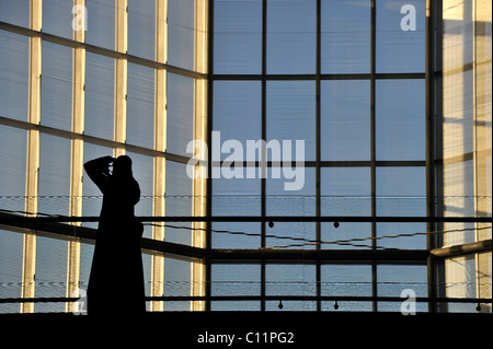 Photographe en tenue traditionnelle avec abayah et voile, tir intérieur de l'atrium, Musée d'Art Islamique, conçu par I.M. PEI Banque D'Images