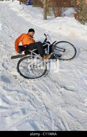 Un cycliste se brisant sur route glissante couverte de neige Banque D'Images