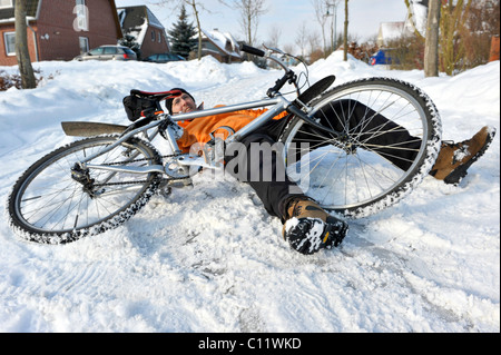 Un cycliste se brisant sur route glissante couverte de neige Banque D'Images